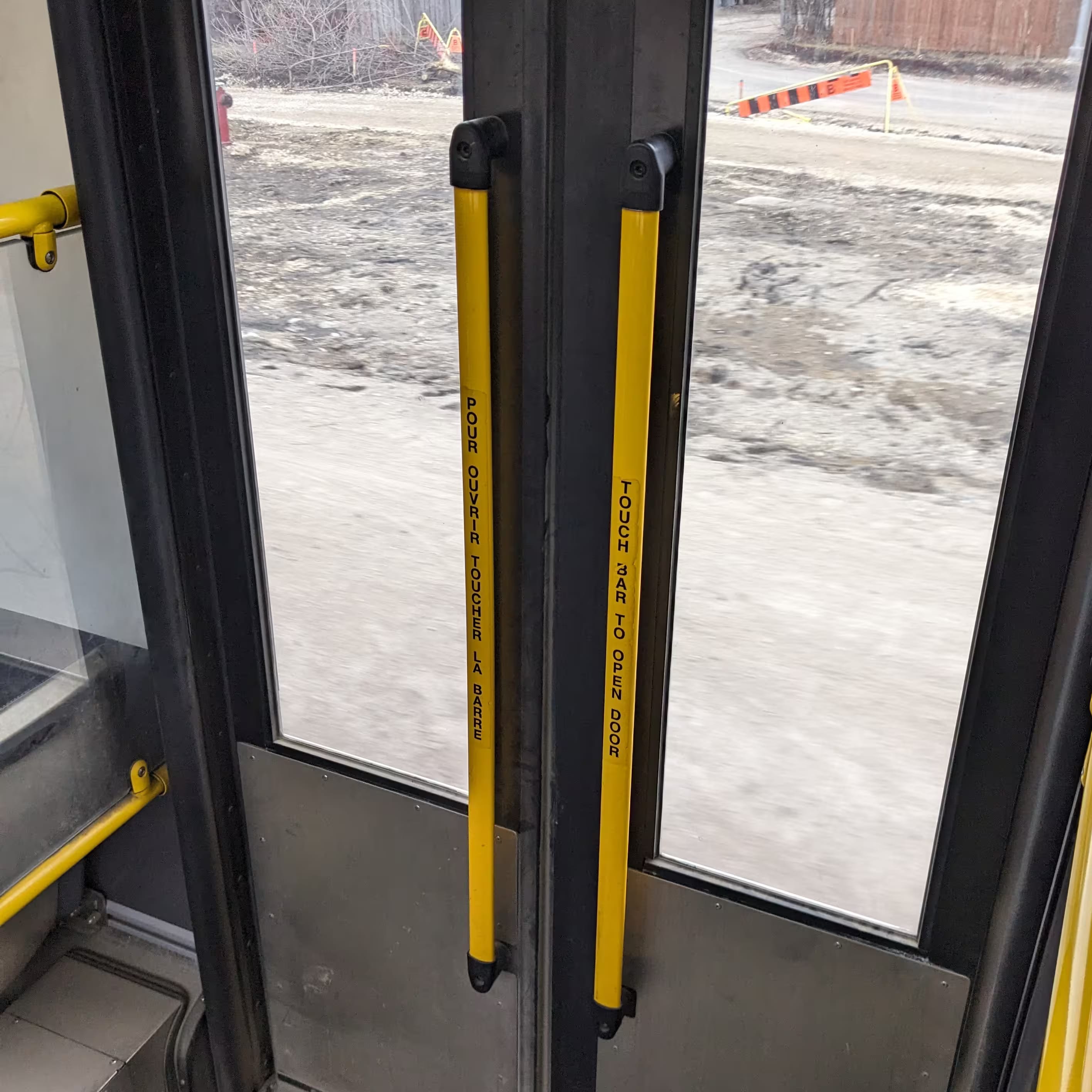 The back side door of the bus, with yellow handles