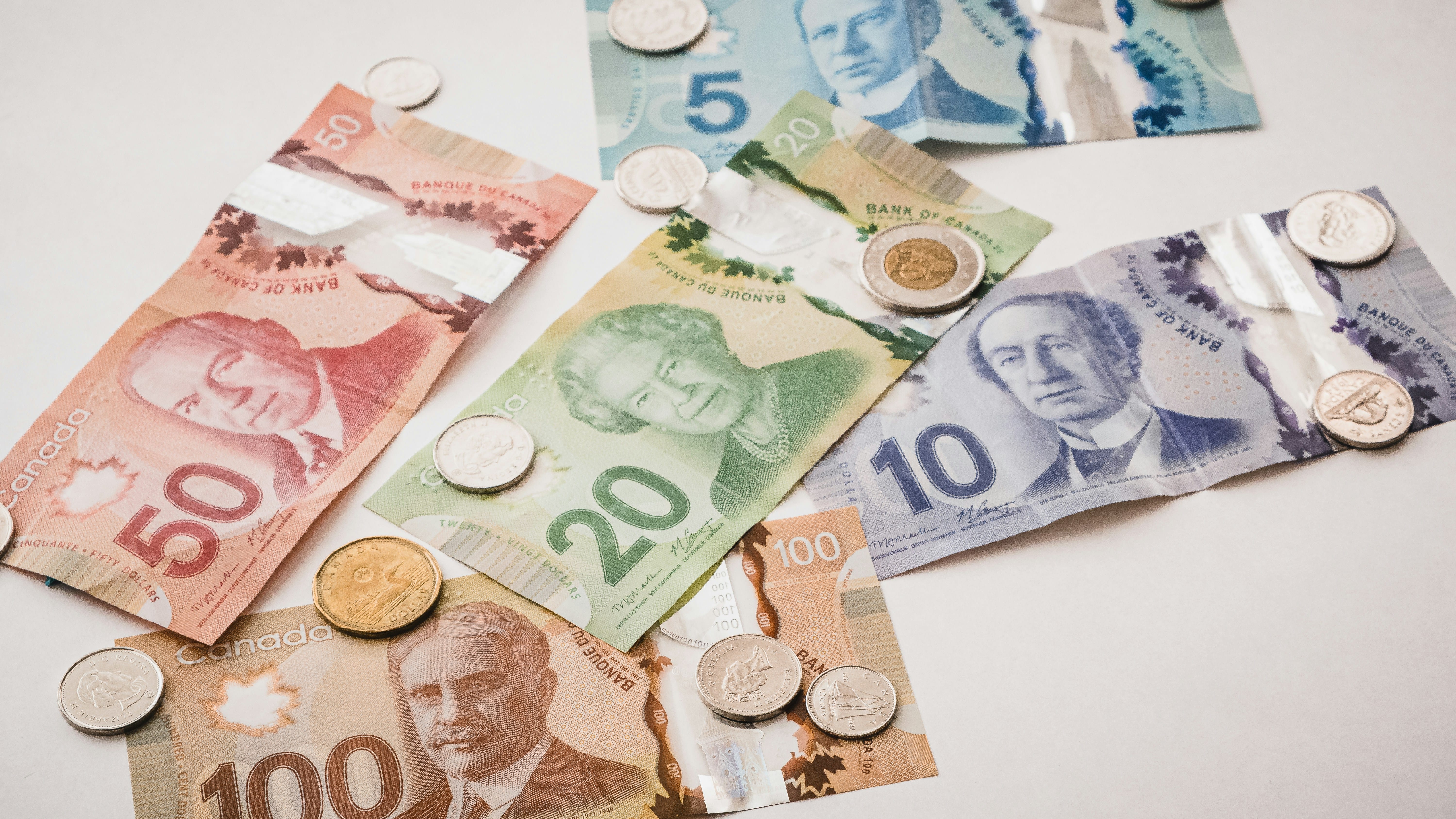 Canadian dollar bills and coins scattered
