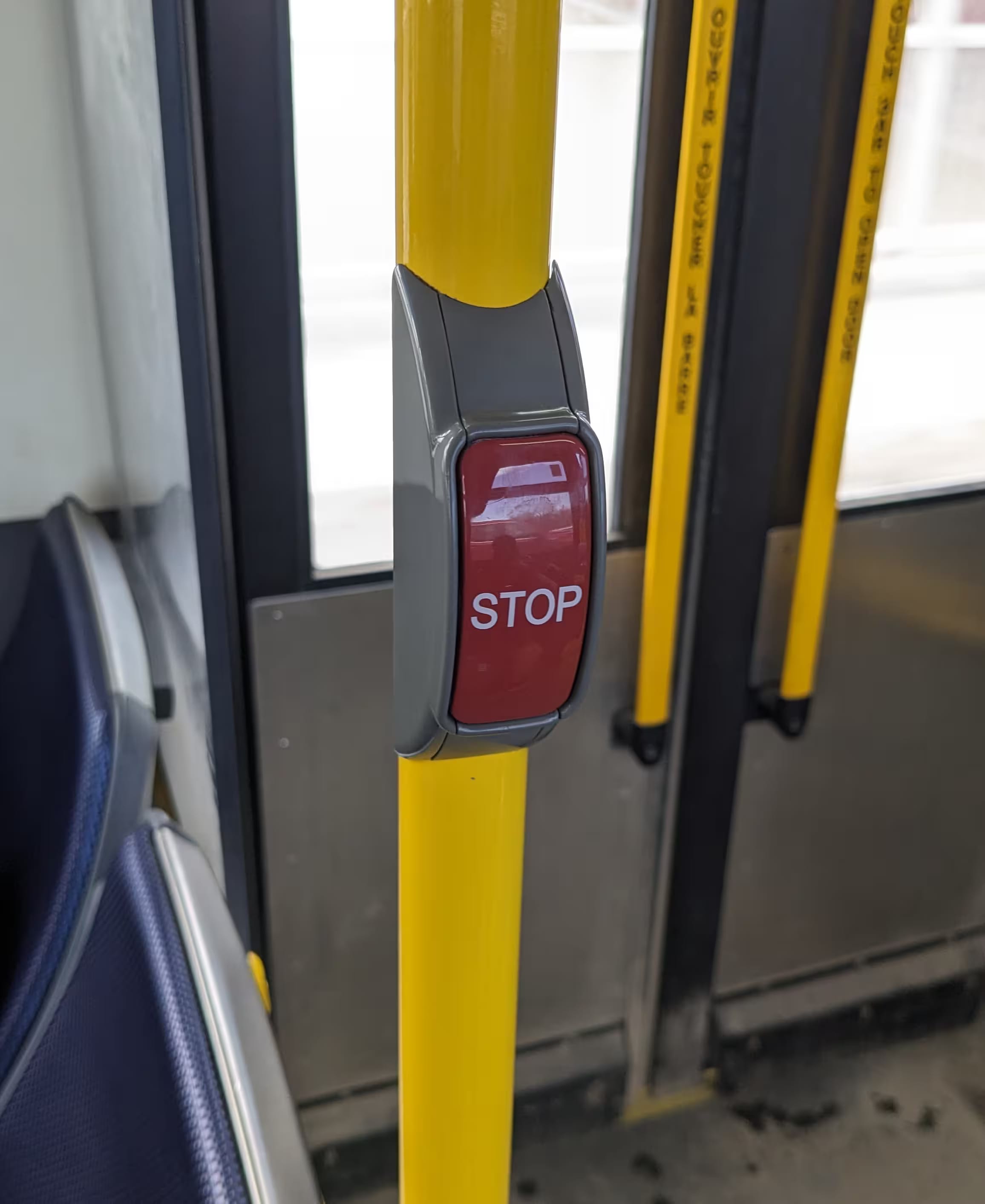 A red stop button on a yellow pole